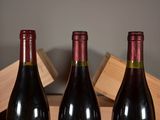 three bottles of wine sitting on a table next to a wooden box