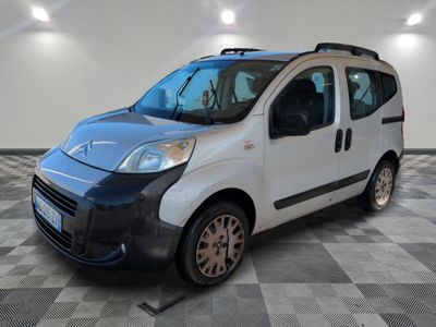the small white van is parked on a checkered tile floor