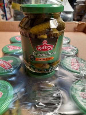 un bocal de cornichons posé sur une table