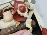 a hand that is holding a small doll in a box