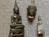 deux petites statues de Bouddha et une statue de Bouddha posée sur une table