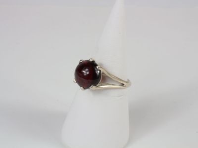 a close up of a ring with a red stone on it