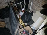 a pile of trash on the ground next to a brick wall