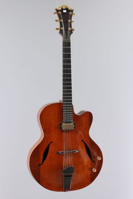 a close up of a guitar on a stand against a white background