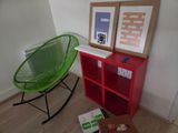 une chaise verte et une bibliothèque rouge dans une pièce