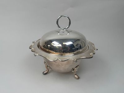 an antique silverplated bowl with a domed lid on a stand