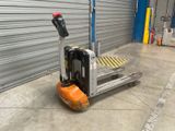 un chariot élévateur équipé d'une fourche, devant la porte d'un garage