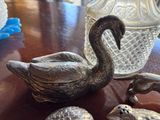 a silver swan figurine sitting on a table next to other silver figurines