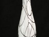 a white vase with black and white swirly designs on it