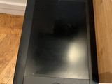 a black tablet computer sitting on a desk next to a wooden desk