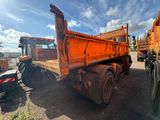 a large orange dump truck that is parked in a lot