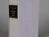 a white book sitting on top of a table next to a gray wall