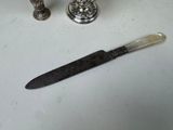 a knife that is laying on a table next to a candle