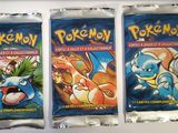 three packs of pokemon trading cards sitting on top of a counter