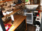 a small kitchen with stone walls and a wooden counter