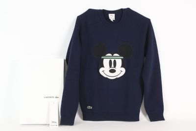a sweatshirt with a mickey mouse face on it next to a card