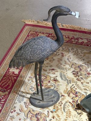a statue of a bird on a rug on the floor