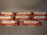 six model ships are lined up on wooden bases