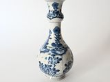 a blue and white vase sitting on a white surface