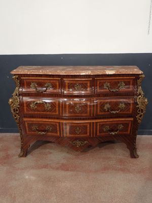 a wooden dresser with a marble top on a carpeted floor