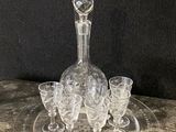 an image of a clear glass decanter and four glasses on a table