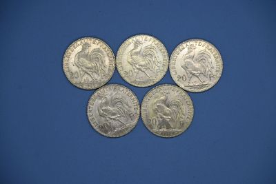 six pièces d'argent de tailles et de formes différentes sur un fond bleu