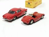 two toy cars sitting next to each other on a white surface