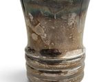 un vase en argent posé sur une table blanche