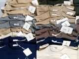 several pairs of sweaters are stacked on top of each other on a table