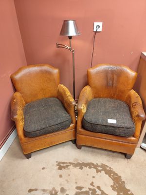 deux fauteuils en cuir marron placés l'un à côté de l'autre dans une pièce