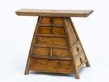 une petite table en bois surmontée de tiroirs