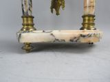 a marble and brass clock on a stand on a table