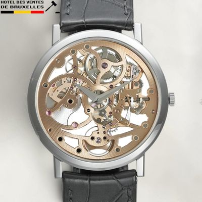 a close up of a watch on a white surface
