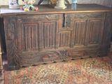 a large wooden chest with a vase on top of it