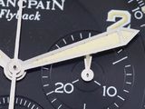 a close up of a black watch with a yellow second hand