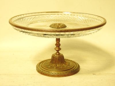 a glass cake plate on a gold stand