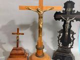 trois croix et un crucifix posés sur une table