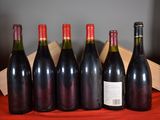 six bottles of wine are lined up in a row on a table