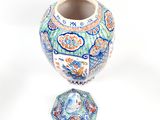 a blue and white vase with a lid sitting on a white surface