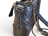 a black purse with a chain hanging from it ' s side
