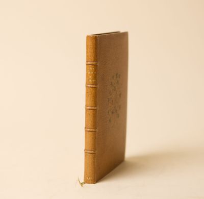 un vieux livre posé sur une table blanche à côté d'un mur blanc