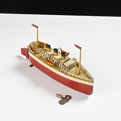 une petite maquette de bateau posée sur une surface blanche