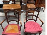 two wooden chairs with red cushions sit next to each other in a room