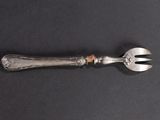 a silver spoon and a fork on a black surface