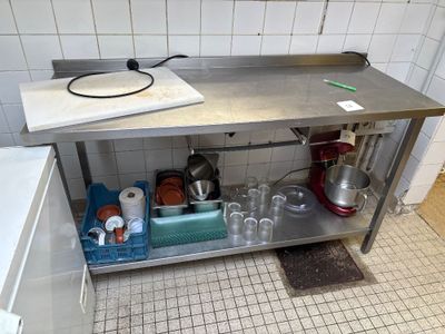 une cuisine avec un évier et un plan de travail sur lequel sont posés de nombreux plats