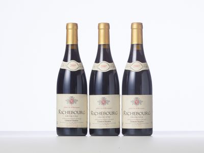 three bottles of wine are lined up on a table