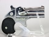 a silver revolver with a black grip on a clear stand