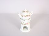 a small white teapot with a pink rose design on it