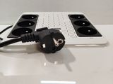 a black and white power strip attached to a white laptop