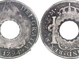 a close up of a coin with a hole in the middle of it